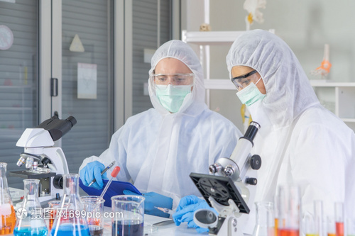 一家西方科学夫妇在实验室或中在技术医学化保健研究实验科学等领域研究测试管以分析和开发共生19疫苗
